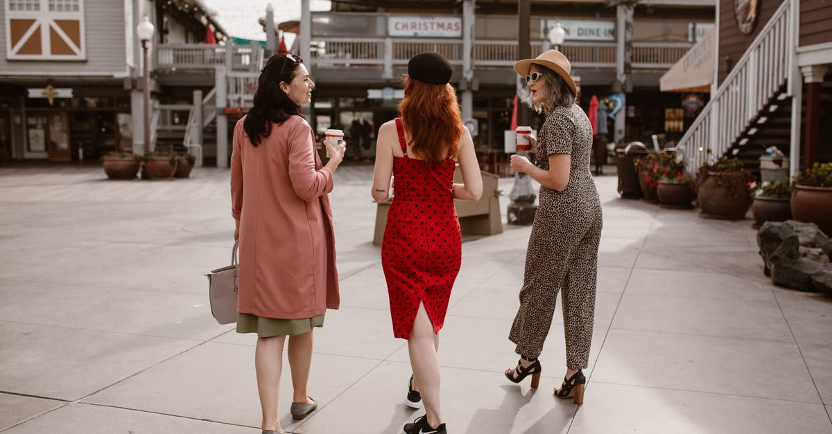 Visiting Canada from Europe, with weekend trip to the US – will we need testing when going back to Canada? - Elegant women walking on street and drinking takeaway coffee