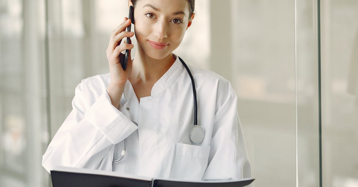 Visiting doctors while staying in Australia? - Positive doctor in medical uniform talking on cellphone in clinic corridor Visiting doctors while staying in Australia? - Positive doctor in medical uniform talking on cellphone in clinic corridor