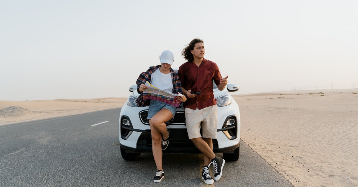 Visiting Dubai as an unmarried couple [duplicate] - Man and Woman Holding a Map While Standing In Front of the White car