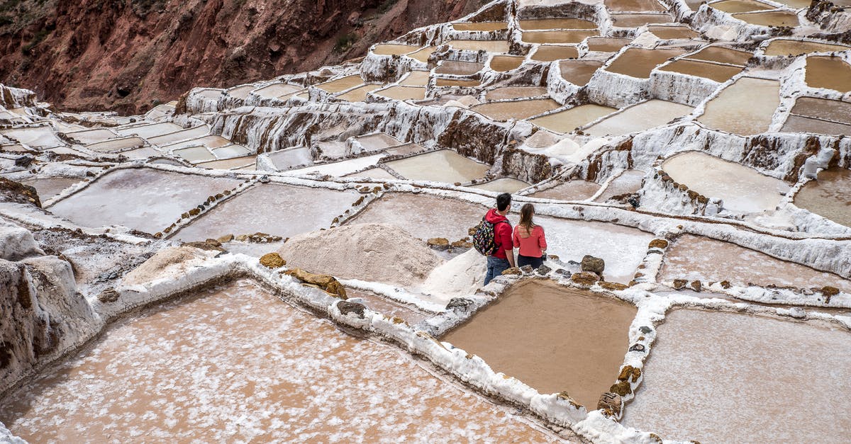 Visiting salt flats in Bolivia from Chile - Tourists Visiting Ancient Saline Terraces in Andes Peru Visiting salt flats in Bolivia from Chile - Tourists Visiting Ancient Saline Terraces in Andes Peru