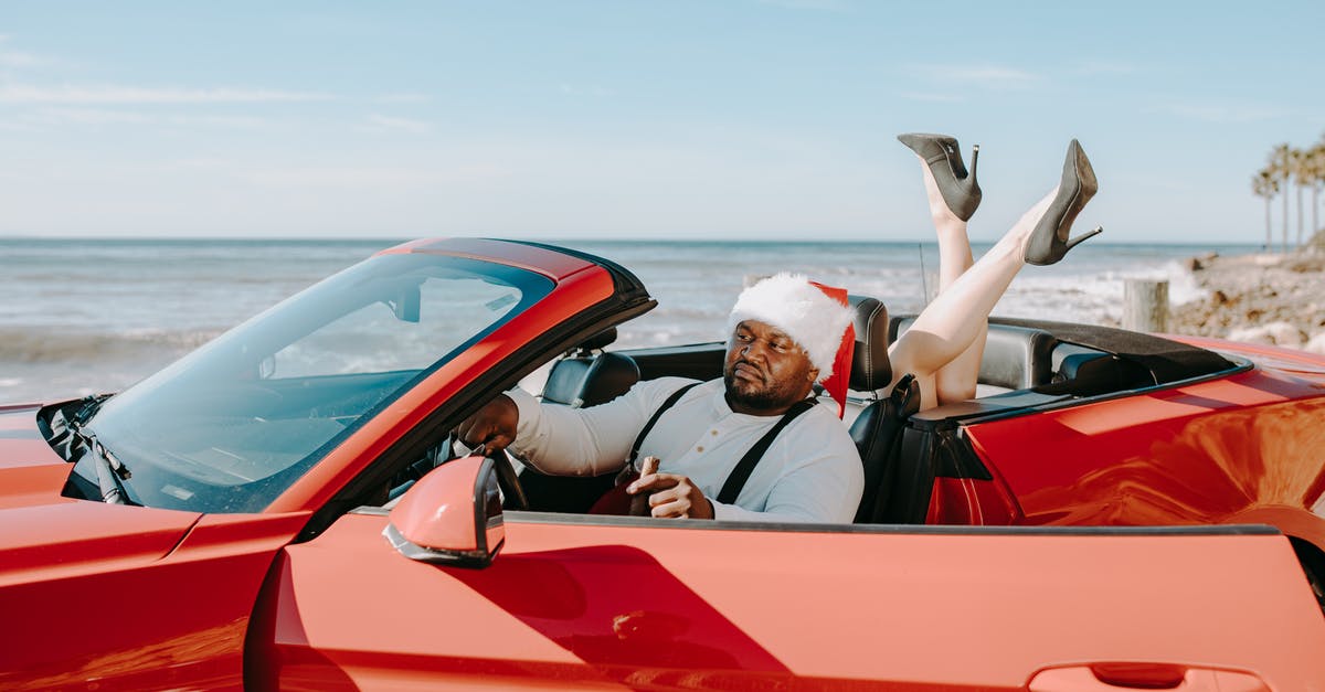 Visiting Yosemite in December - Will car rentals provide me with snow chains? - Man and Woman Riding Red Convertible Car Visiting Yosemite in December - Will car rentals provide me with snow chains? - Man and Woman Riding Red Convertible Car