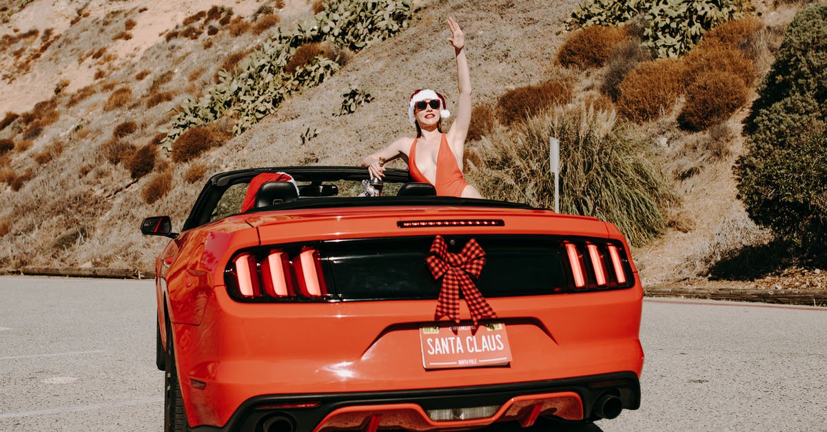 Visiting Yosemite in December - Will car rentals provide me with snow chains? - Woman in White Tank Top Sitting on Red Car Visiting Yosemite in December - Will car rentals provide me with snow chains? - Woman in White Tank Top Sitting on Red Car