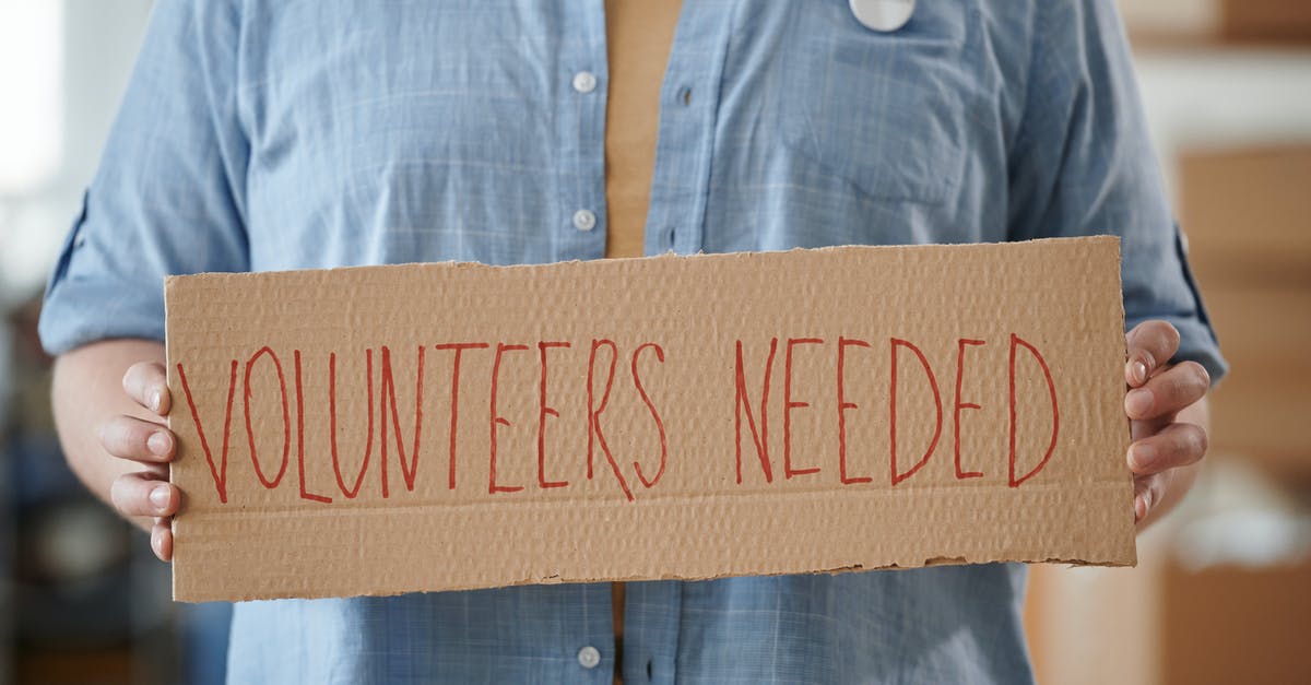 Volunteer in UK – which visa needed? - A Person Holding a Cardboard with Inscription Volunteer in UK – which visa needed? - A Person Holding a Cardboard with Inscription