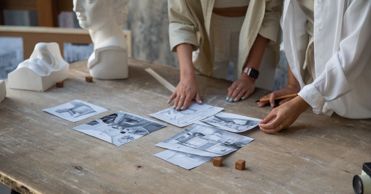 Voluntourism - how to evaluate - Pencil Drawings on Wooden Table and Women Hands Voluntourism - how to evaluate - Pencil Drawings on Wooden Table and Women Hands