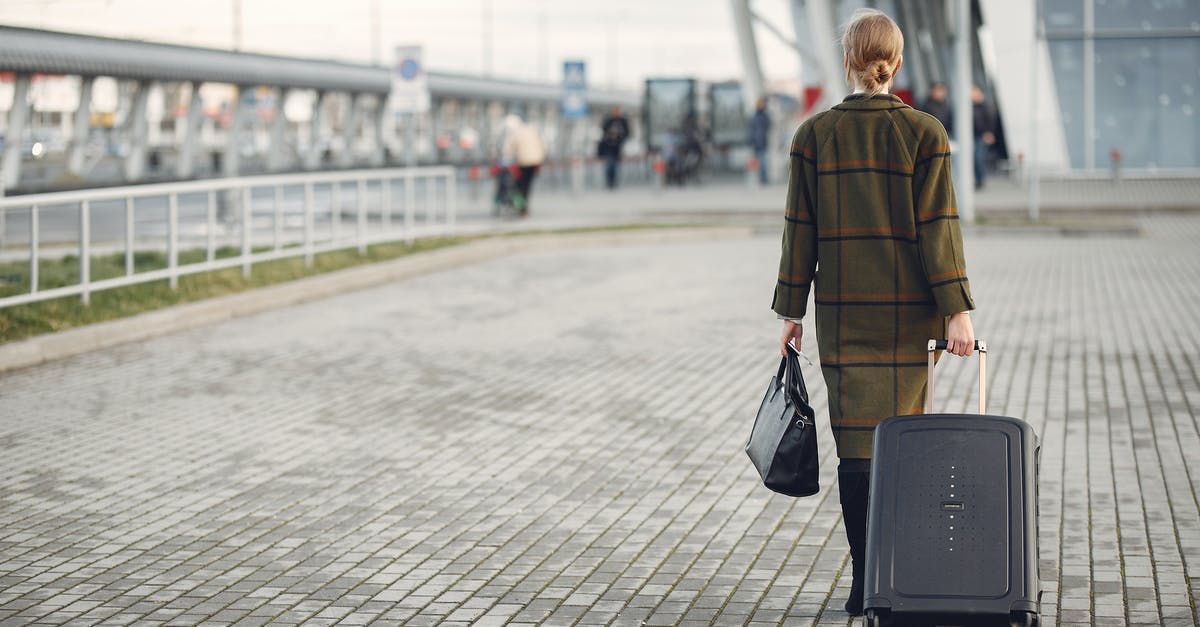 Waiting after international flight before clearing customs - Unrecognizable woman with suitcase walking near airport terminal Waiting after international flight before clearing customs - Unrecognizable woman with suitcase walking near airport terminal