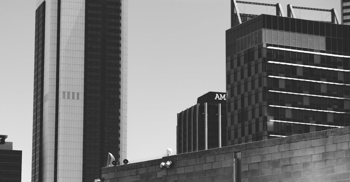 Waiting area near 7th avenue, 27th street, New York - Black and white exteriors of different modern buildings located in commercial district of city against cloudy sky Waiting area near 7th avenue, 27th street, New York - Black and white exteriors of different modern buildings located in commercial district of city against cloudy sky