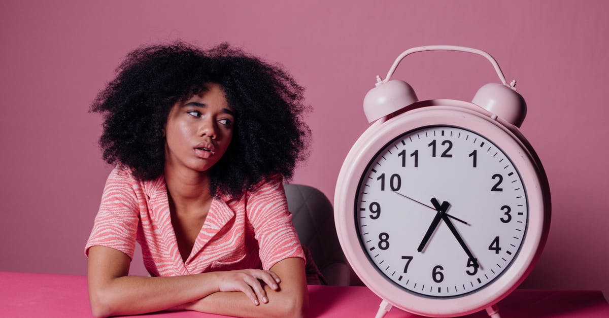 Waiting times at Ukrainian land borders - Woman Looking at a Big Pink Alarm Clock Waiting times at Ukrainian land borders - Woman Looking at a Big Pink Alarm Clock