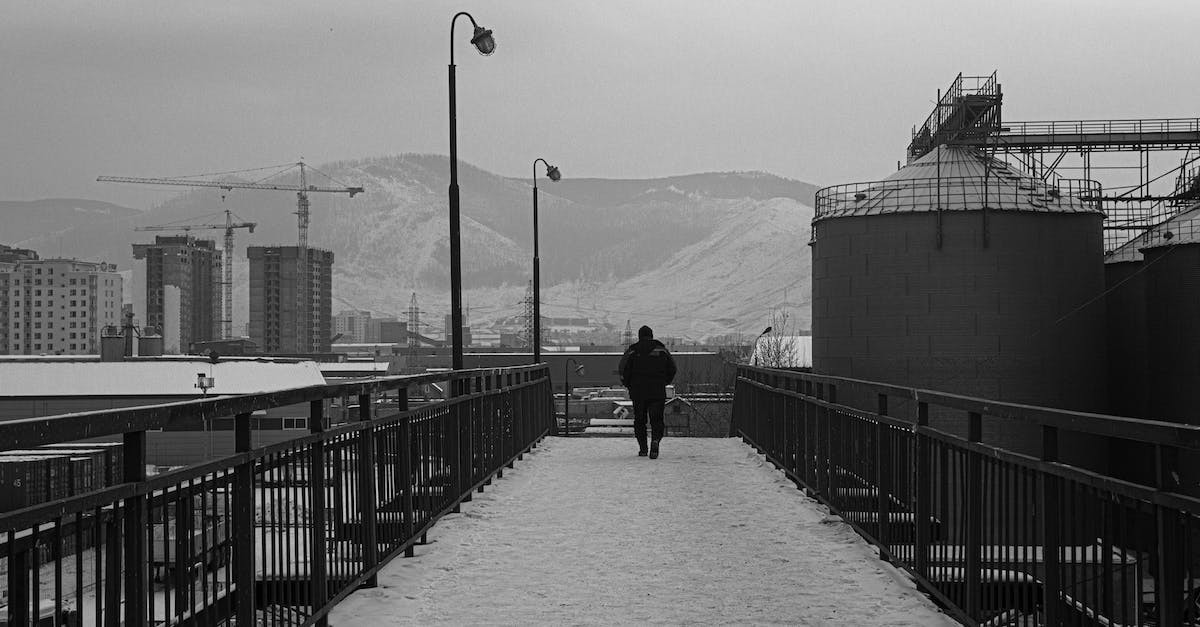 Walking back down Grouse Mountain, after doing the Grouse Grind? - Man Walking on a Bridge in Winter in City Walking back down Grouse Mountain, after doing the Grouse Grind? - Man Walking on a Bridge in Winter in City