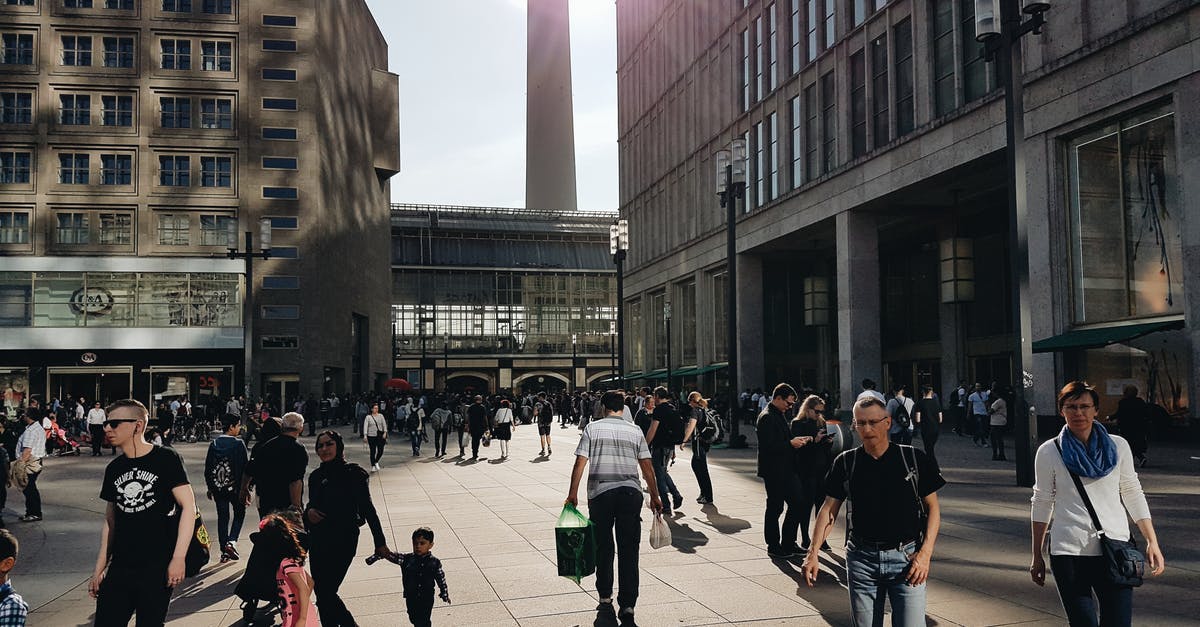 Walking experience in Berlin - Man in Black Crew-neck T-shirt Walking Near Building Walking experience in Berlin - Man in Black Crew-neck T-shirt Walking Near Building