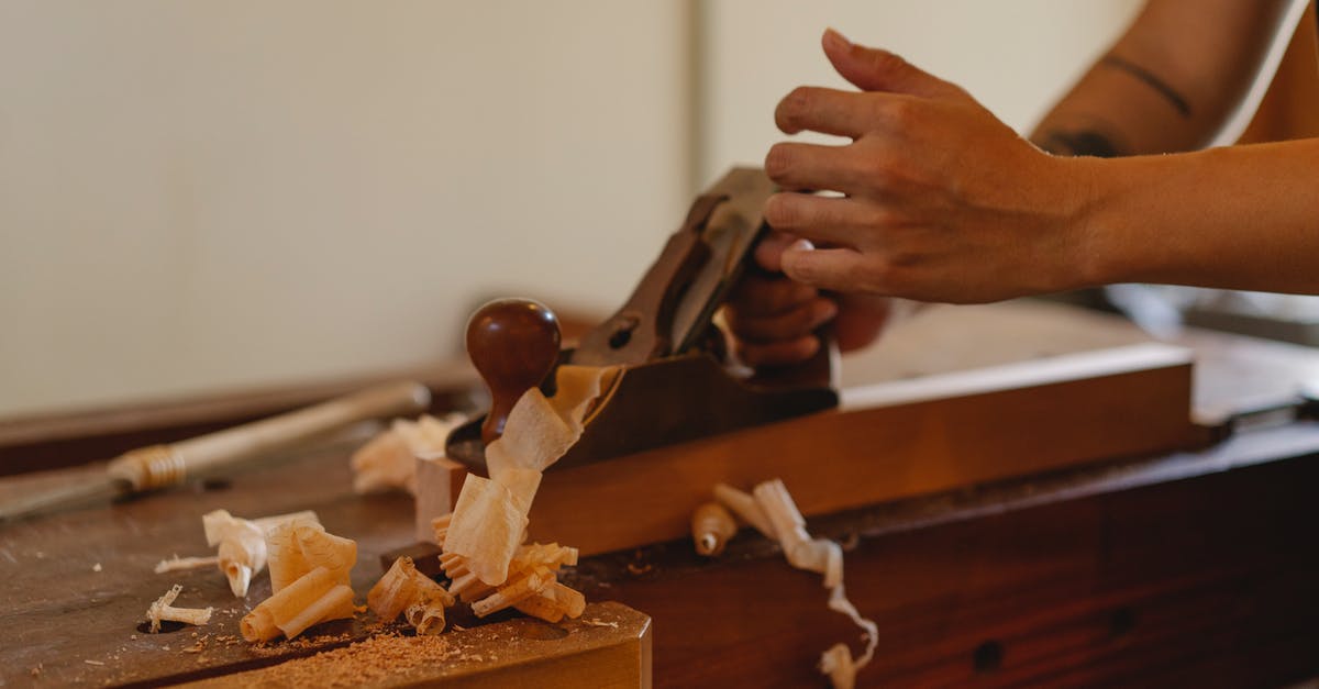 Want to go to Visit Russia but Can I board the plane from Delhi, India, instead of Dhaka Bangladesh? - Crop joiner shaping hardwood plank with jack plane working at table in modern workshop