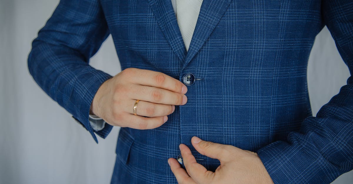Wearing neoprene suit in airplane? - Person Putting Button of Vest Wearing neoprene suit in airplane? - Person Putting Button of Vest