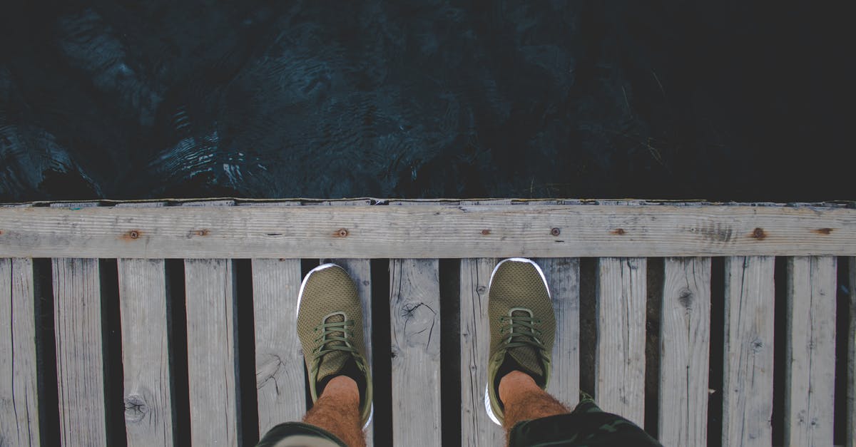 Wearing shorts with hairy legs in Moscow - Man Standing on Brown Wooden Dock