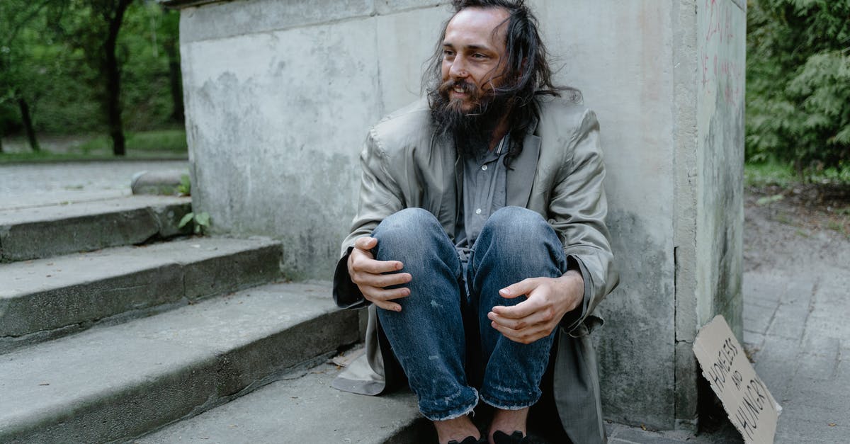 Wearing Vibram FiveFingers while travelling in Europe - Man in Gray Coat Sitting on Concrete Stairs