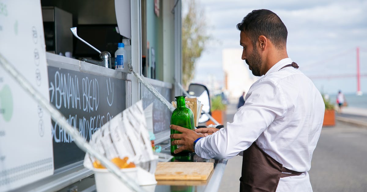Website to arrange rides with trucks - Ethnic man putting glass bottles on counter Website to arrange rides with trucks - Ethnic man putting glass bottles on counter