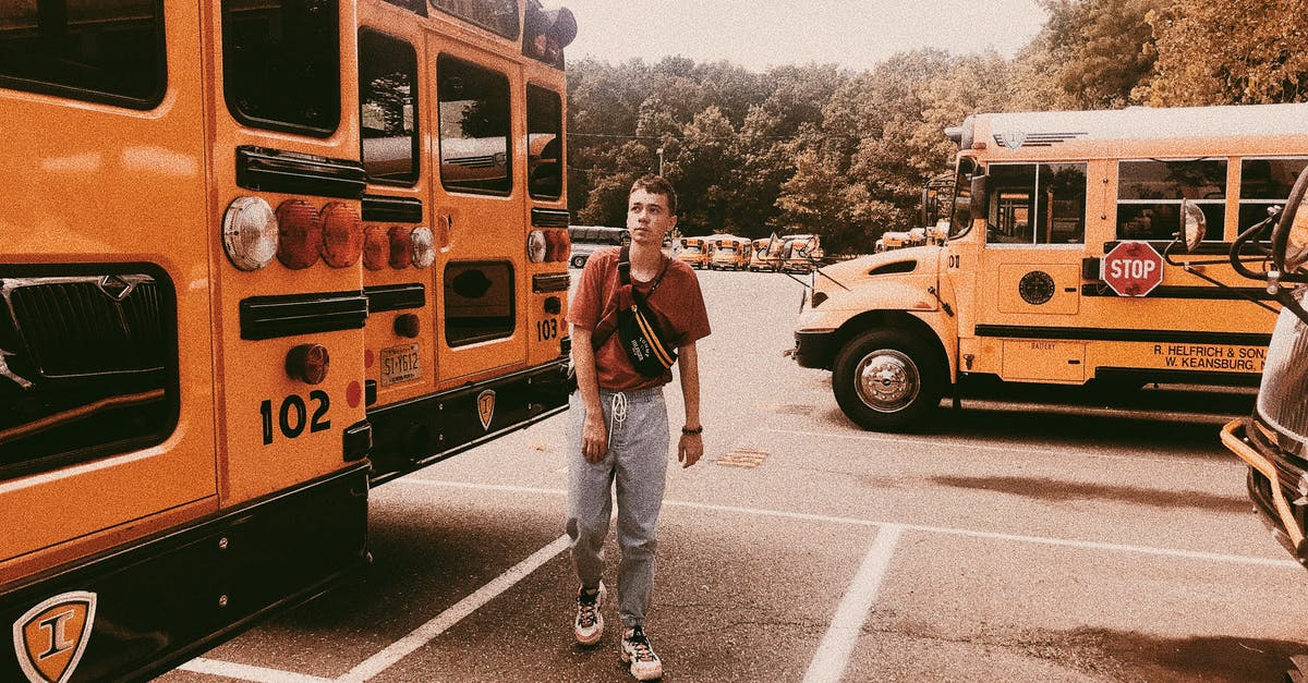 Weekend parking at PATCO stations - Stylish young man walking on parking lot with school buses Weekend parking at PATCO stations - Stylish young man walking on parking lot with school buses