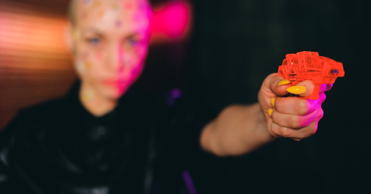 Weird points calculation at Qantas Frequent Flyer - Eccentric bald woman pointing toy gun in dark studio Weird points calculation at Qantas Frequent Flyer - Eccentric bald woman pointing toy gun in dark studio