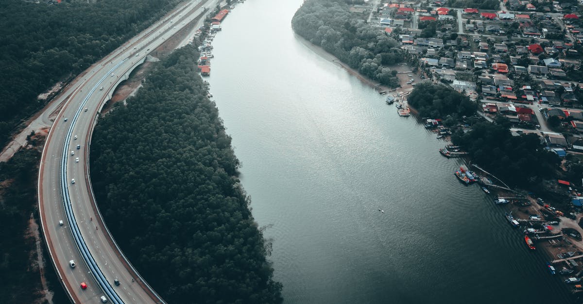 What's the cheapest way to get from Melbourne's two airports to Southern Cross Station? [duplicate] - Aerial view of bridge with cars running on shore with green trees and modern city