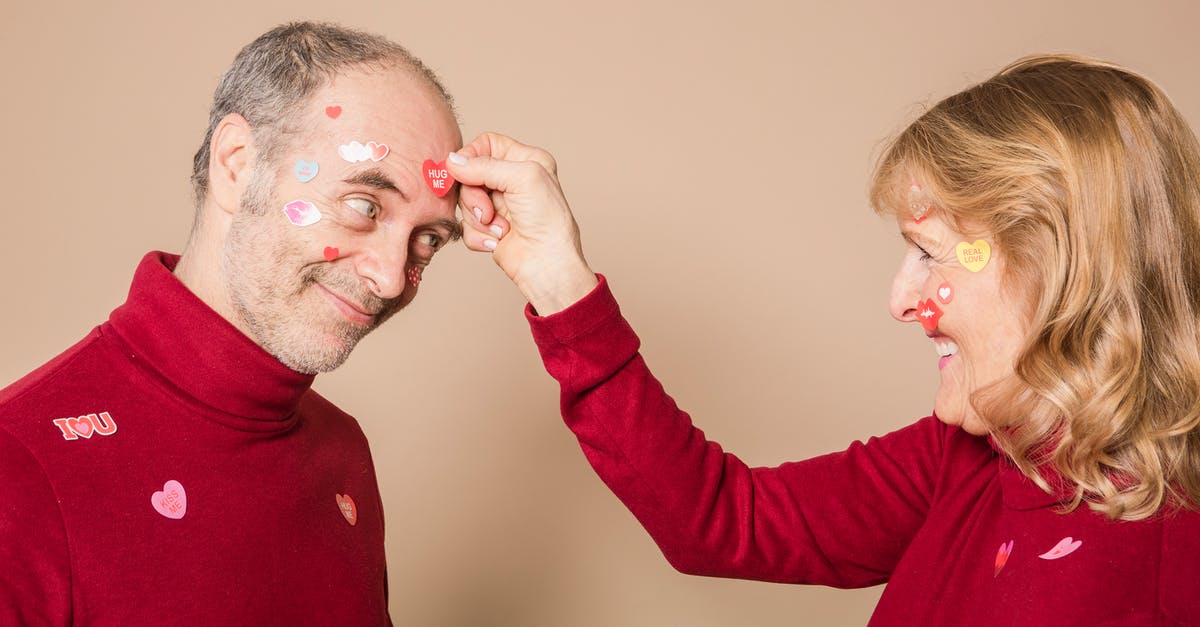What's the point in placing small barcode stickers on one's check-in bags? - Woman Putting Stickers on Man's Face