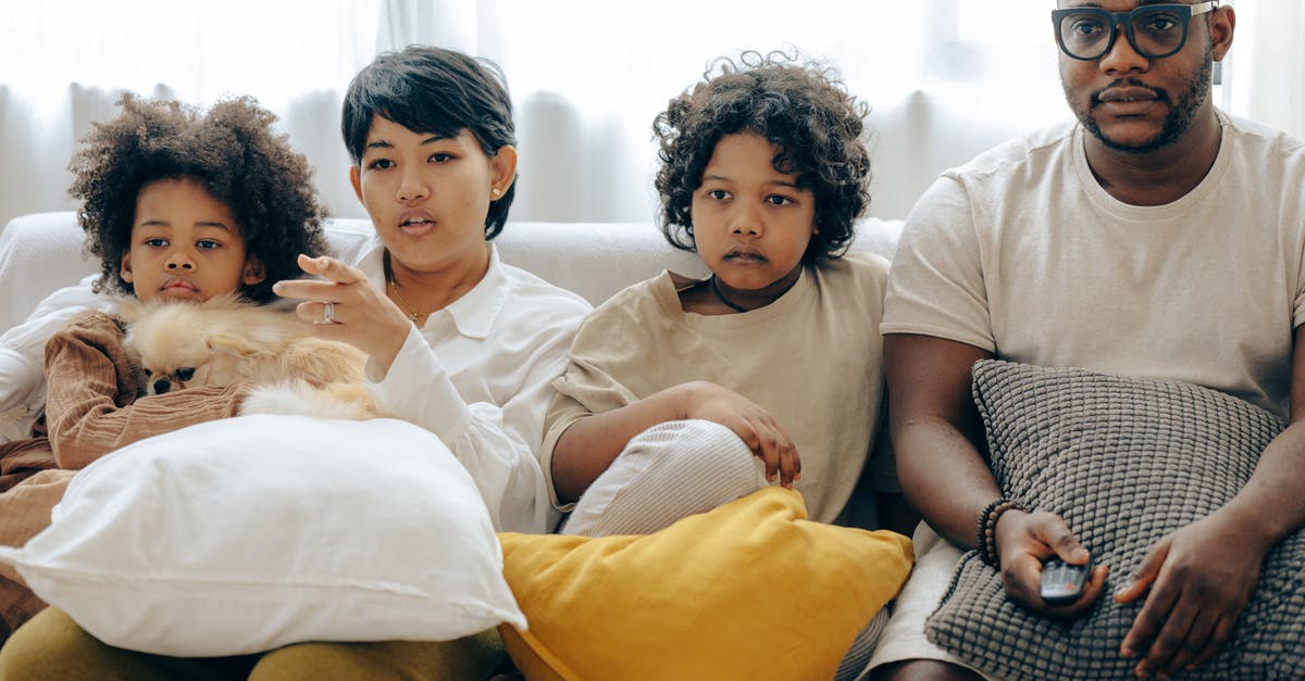 What's the point of government officials checking IDs on domestic flights? [duplicate] - Multiethnic family watching TV with dog on sofa