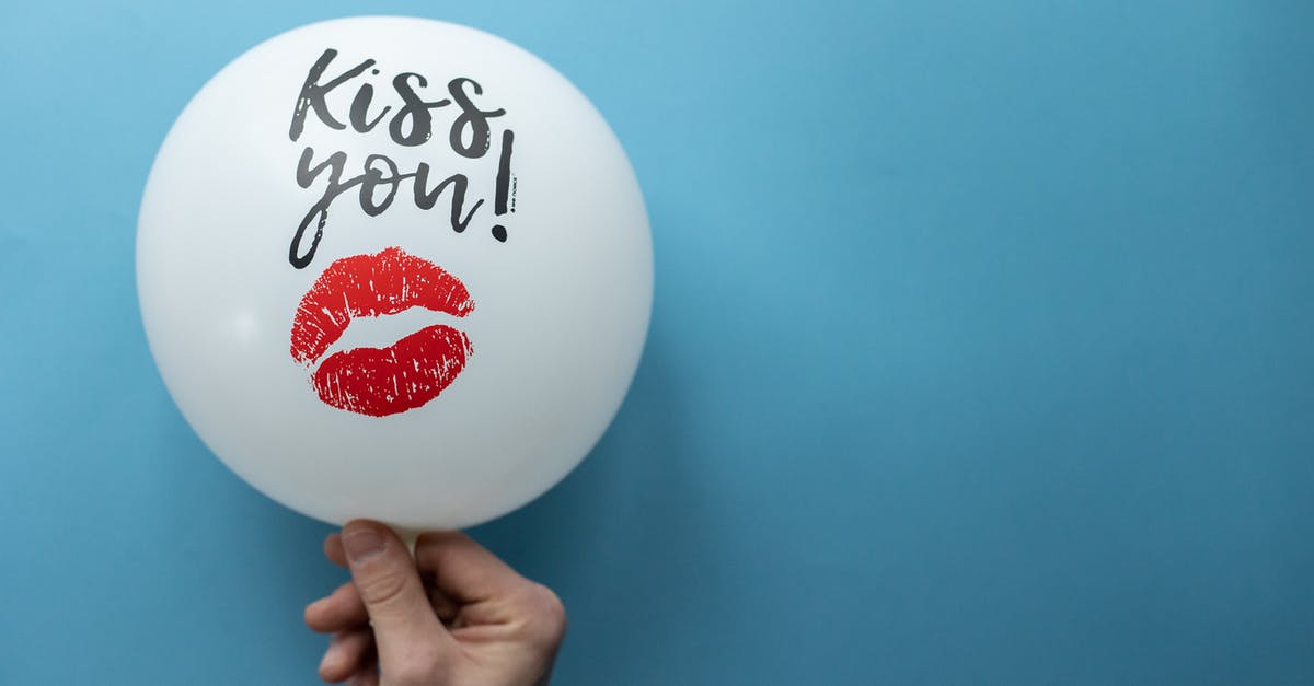What are some practical hand-out gifts you can take with you when travelling? - Unrecognizable person demonstrating white balloon with Kiss You inscription and kiss mark on blue background in studio during holiday celebration What are some practical hand-out gifts you can take with you when travelling? - Unrecognizable person demonstrating white balloon with Kiss You inscription and kiss mark on blue background in studio during holiday celebration