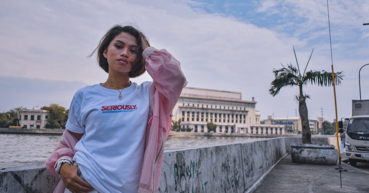 What are the buildings in this photo of Atlanta? - Woman in Pink Jacket Standing Near Body of Water What are the buildings in this photo of Atlanta? - Woman in Pink Jacket Standing Near Body of Water