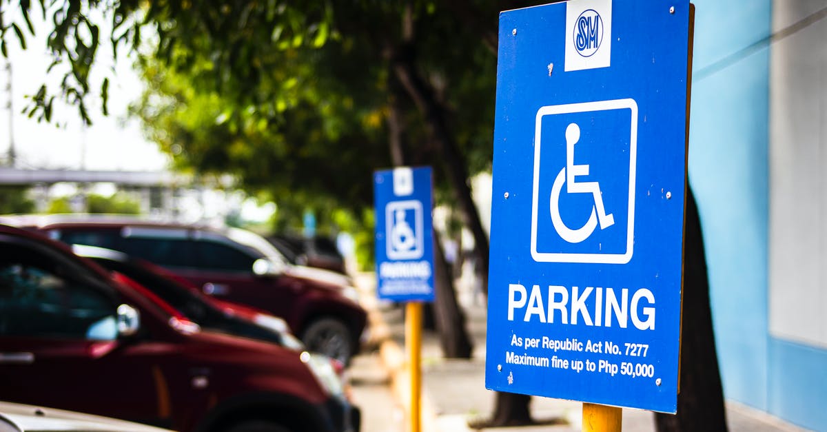 What are the parking regulations in Brooklyn? - Signboard representing rule for disabled people parking only near vehicles and sidewalk in city What are the parking regulations in Brooklyn? - Signboard representing rule for disabled people parking only near vehicles and sidewalk in city