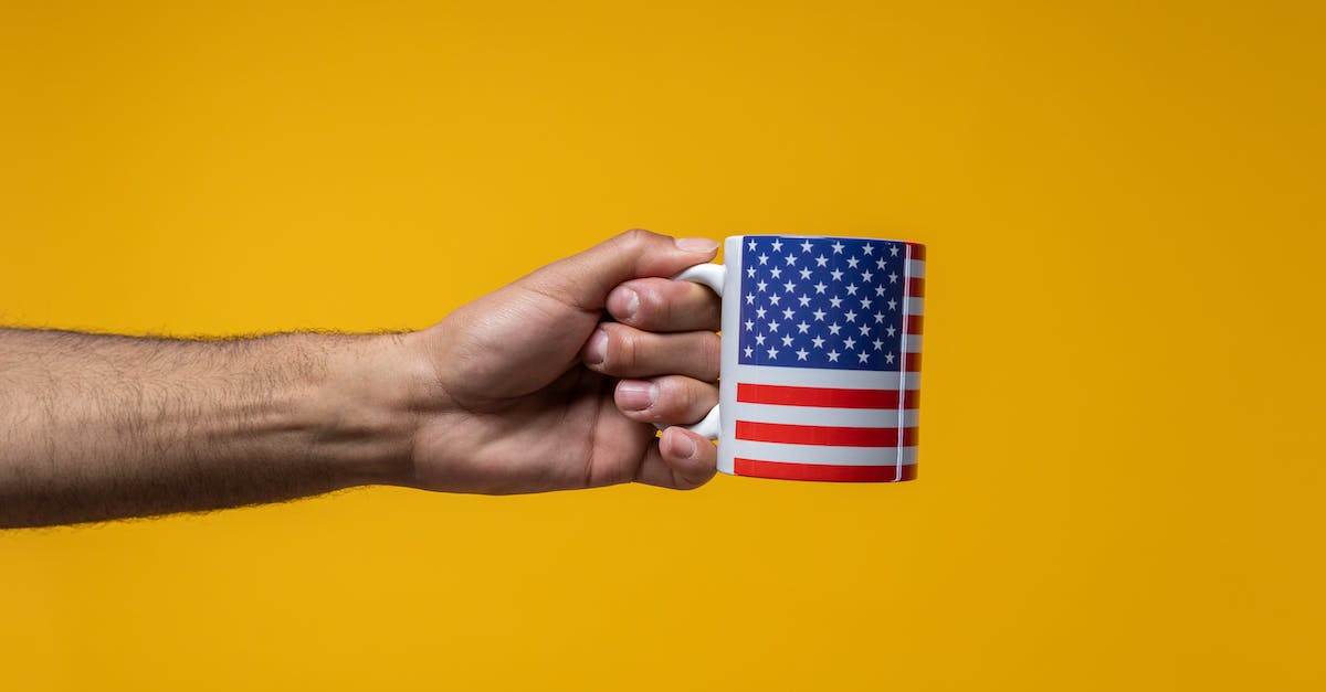 What are the prices of coffee in Poland compared to USA - Person Holding a Mug with a US Flag Design What are the prices of coffee in Poland compared to USA - Person Holding a Mug with a US Flag Design
