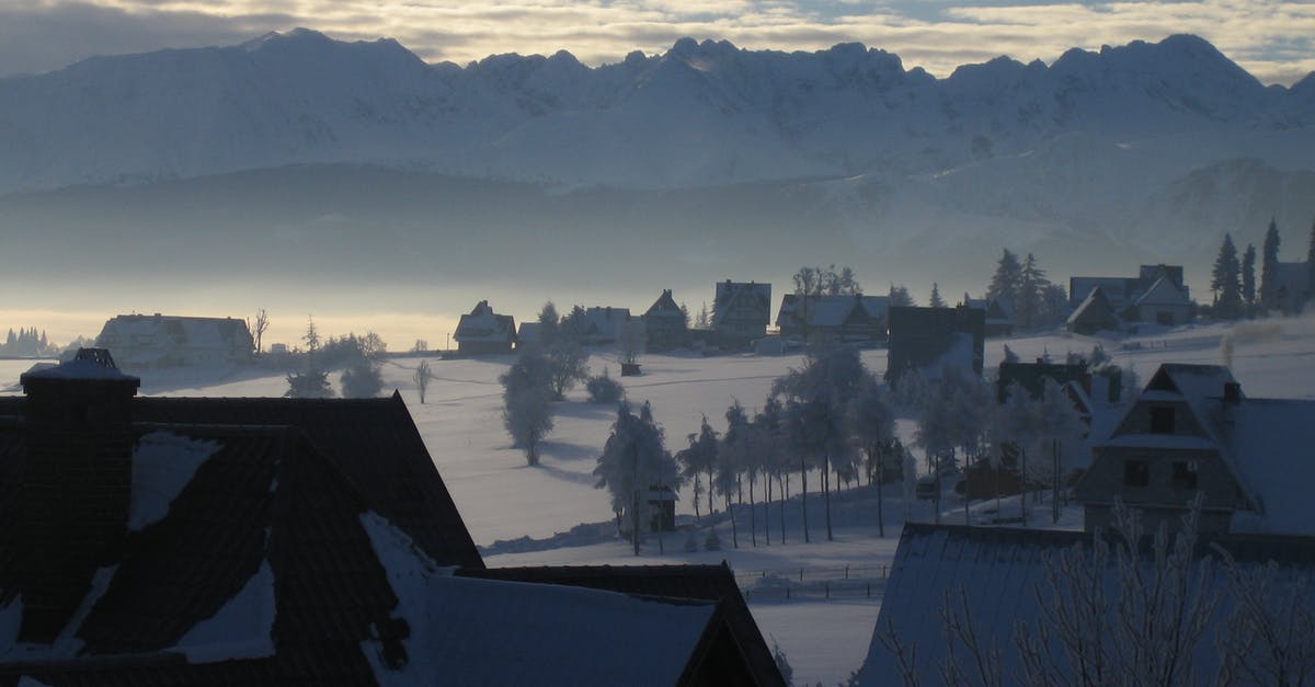 What are these huge ‘fields’ of light just north of Amsterdam? - Houses in fields covered with snow against rocky mountain range in soft light What are these huge ‘fields’ of light just north of Amsterdam? - Houses in fields covered with snow against rocky mountain range in soft light