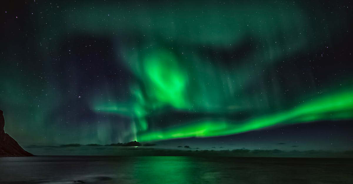 What are these mysterious green balls in the sea in New Caledonia? - Starry night sky with green polar lights over waving ocean in mountainous terrain in winter What are these mysterious green balls in the sea in New Caledonia? - Starry night sky with green polar lights over waving ocean in mountainous terrain in winter