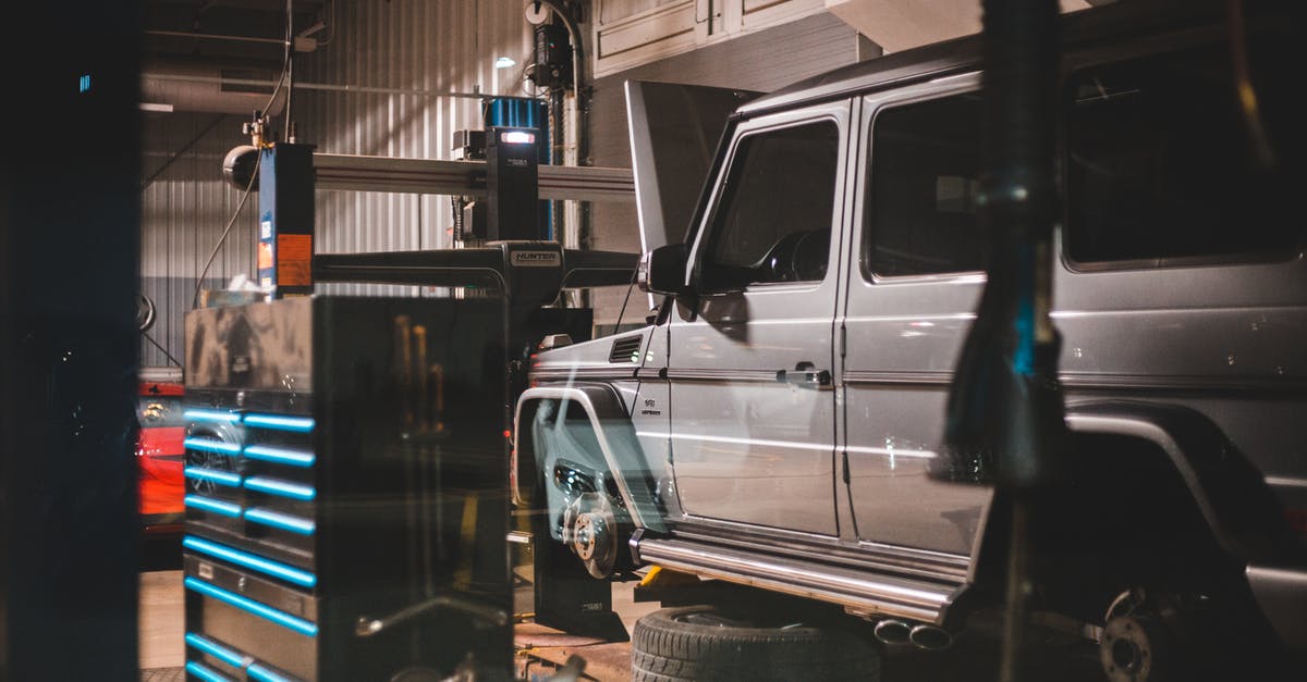 What behind-the-scenes checks happen when passing through passport control at an airport? - Modern massive car in workshop with equipment