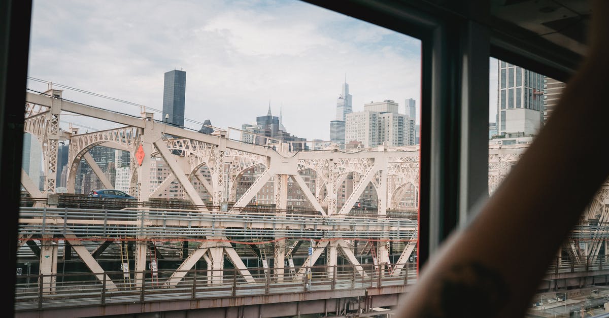 What can be done with hand-luggage for which no cabin space is left? - Crop passenger in cable car contemplating city bridge over river What can be done with hand-luggage for which no cabin space is left? - Crop passenger in cable car contemplating city bridge over river