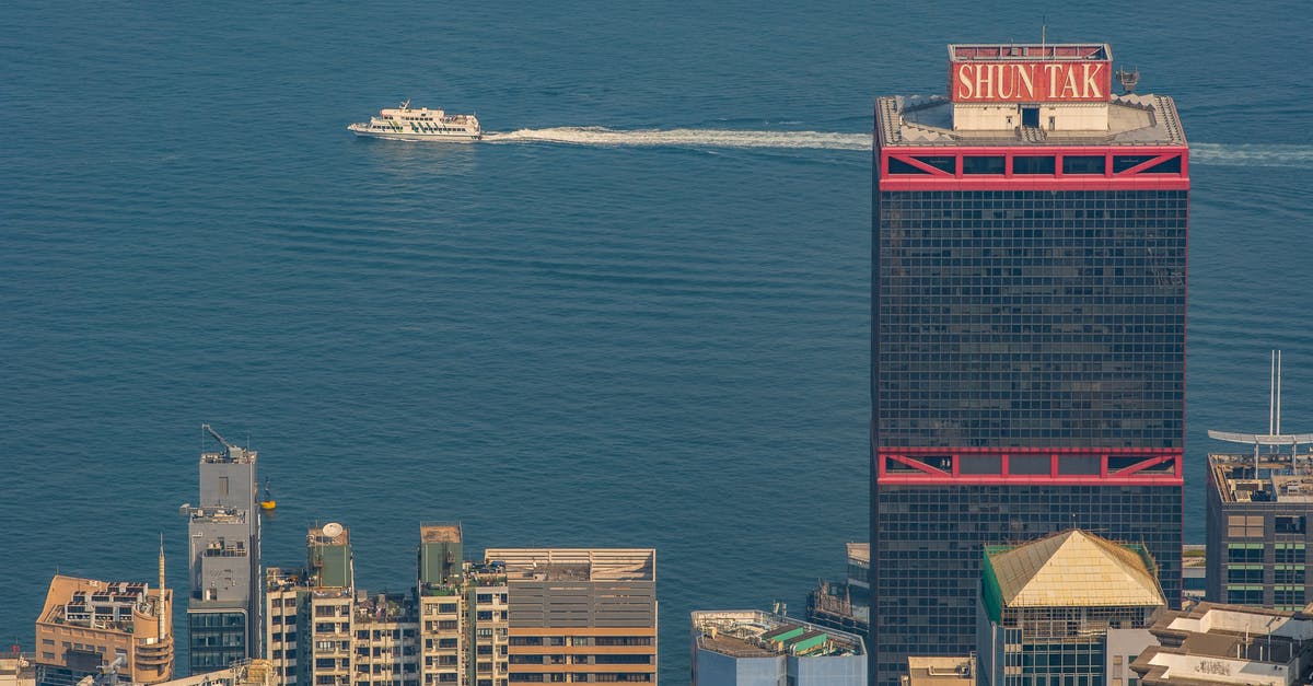 What can I do in Hong Kong with a six-hour layover? - White and Blue Boat on Water Near City Buildings