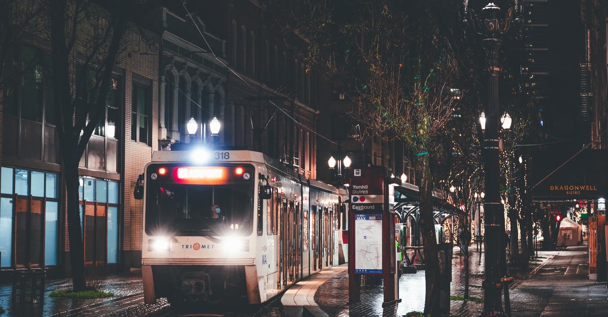 What can I do to make driving in the rain at night easier? [closed] - Modern tramway driving on rails on paved road near aged residential buildings in city at rainy night