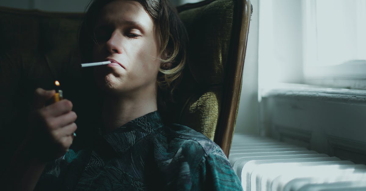 What do I do if I'm falsely accused of smoking in a rented apartment? - Young guy lighting cigarette and smoking while sitting in armchair near window at home What do I do if I'm falsely accused of smoking in a rented apartment? - Young guy lighting cigarette and smoking while sitting in armchair near window at home
