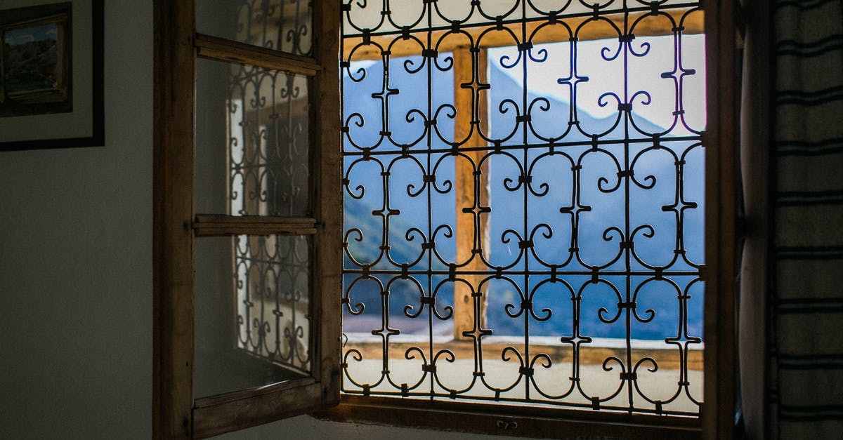 What do I lose by not booking flights through a travel agent? - Opened window with bars viewing majestic mountains and terrace in bright summer sunlight What do I lose by not booking flights through a travel agent? - Opened window with bars viewing majestic mountains and terrace in bright summer sunlight