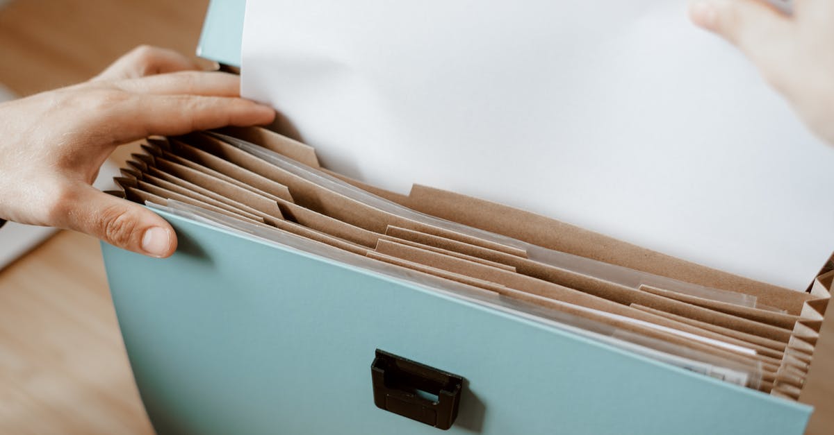 What do I put here? - Person taking white paper from folder What do I put here? - Person taking white paper from folder