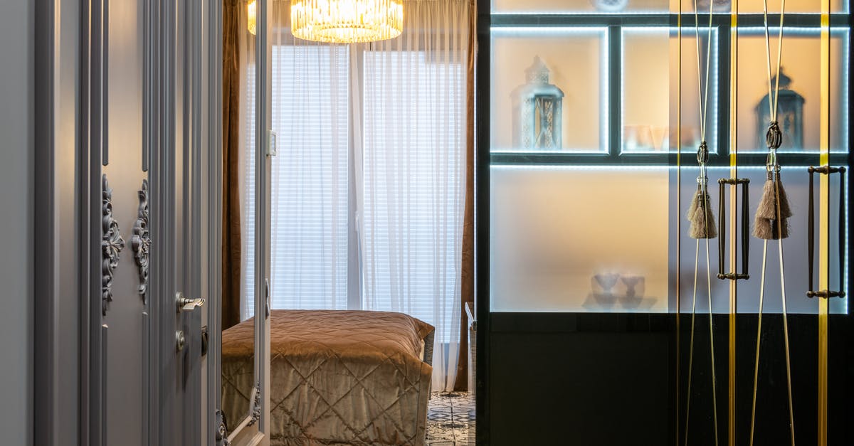 What do tibetan door tassels symbolise? - Open door in house room with assorted lanterns on shelfs and hanging tassels against glowing light What do tibetan door tassels symbolise? - Open door in house room with assorted lanterns on shelfs and hanging tassels against glowing light