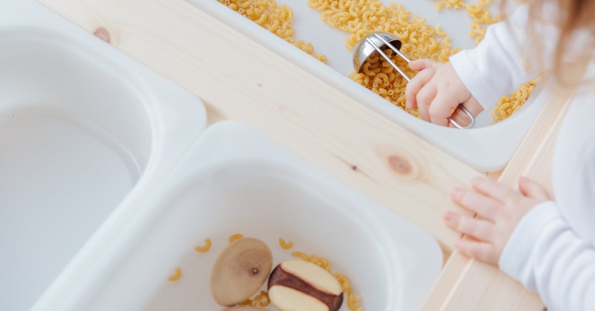 What documents are needed to take a child to the UK? - Little girl collect raw pasta with metal spoon in plastic container What documents are needed to take a child to the UK? - Little girl collect raw pasta with metal spoon in plastic container