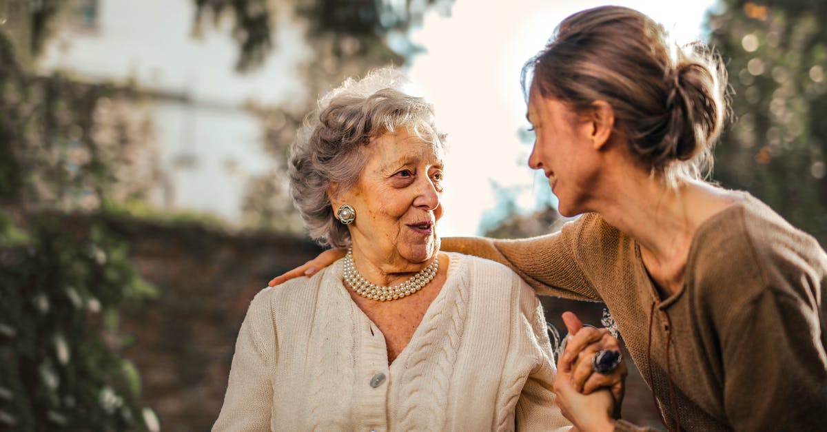 What documents can prove that I am a caregiver in my country of origin? - Joyful adult daughter greeting happy surprised senior mother in garden