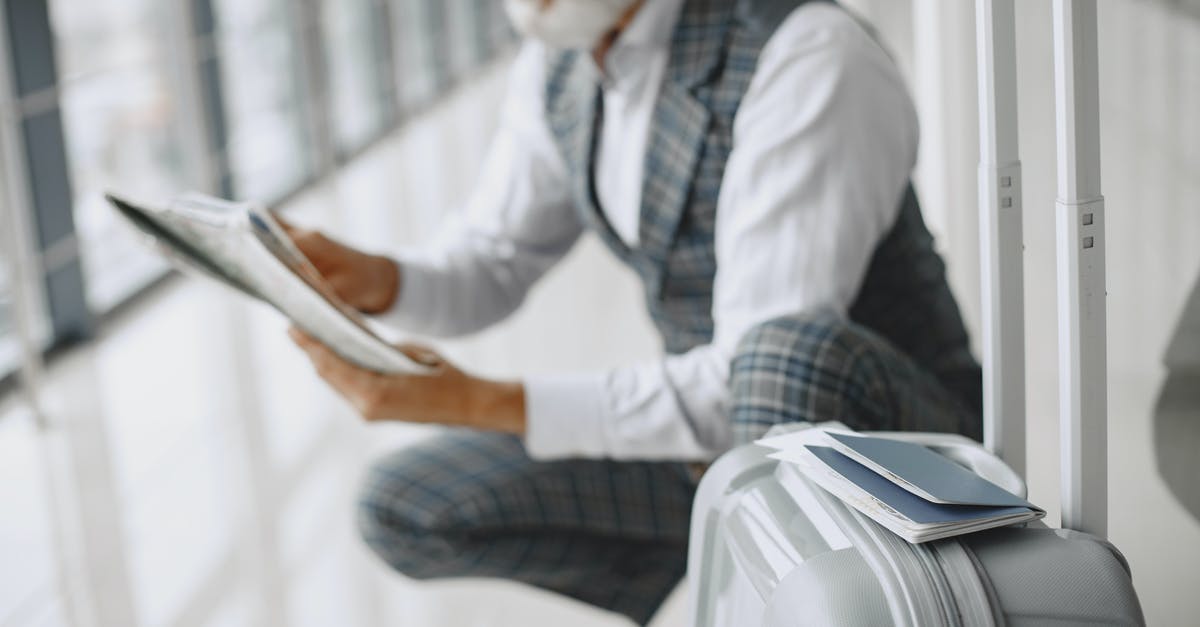 What documents does someone with a long-term visa need to travel to another Schengen country? - A Man Holding a Paper Sitting Near His Luggage What documents does someone with a long-term visa need to travel to another Schengen country? - A Man Holding a Paper Sitting Near His Luggage