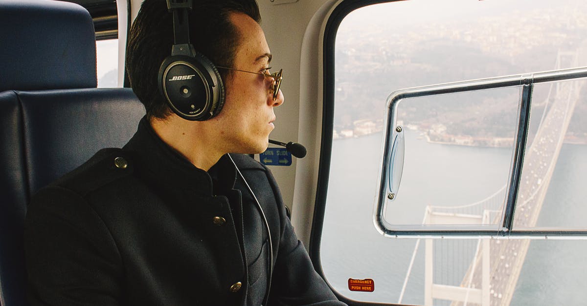 What does an originating flight on your itinerary mean? - Man in Black Jacket Wearing Black Headphones