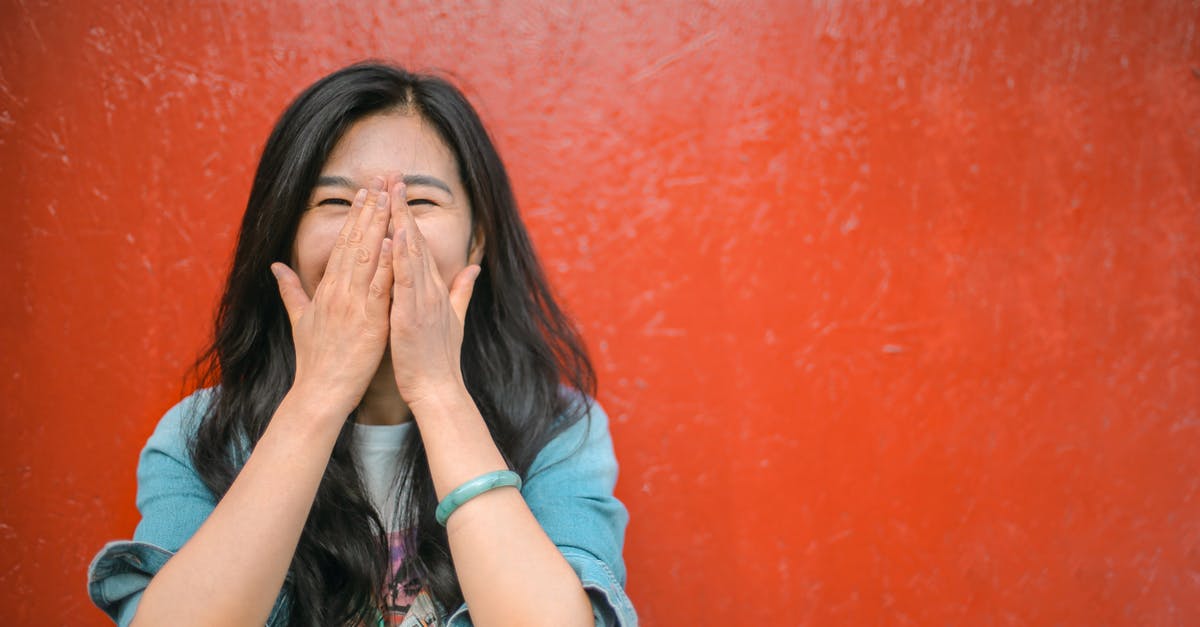 What does red painted bus stop mean in UK? - Young overjoyed Asian female in casual outfit covering face with hands and laughing while standing against vibrant orange wall What does red painted bus stop mean in UK? - Young overjoyed Asian female in casual outfit covering face with hands and laughing while standing against vibrant orange wall