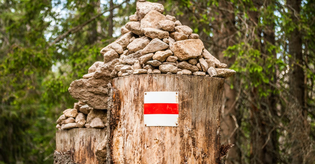 What does this sign on a hiking trail communicate? [closed] - A Pile of Rocks on a Tree Stump