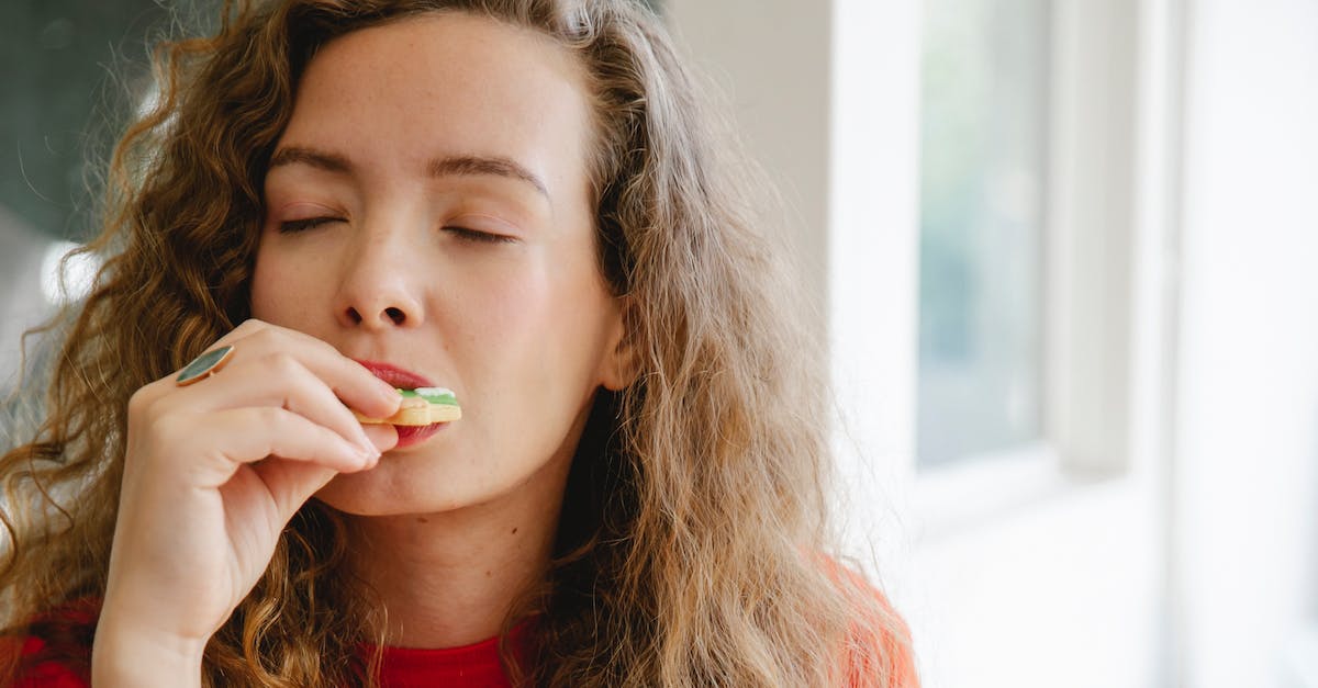 What foods must I try while visiting Australia? [closed] - Pleased woman biting tasty cookie