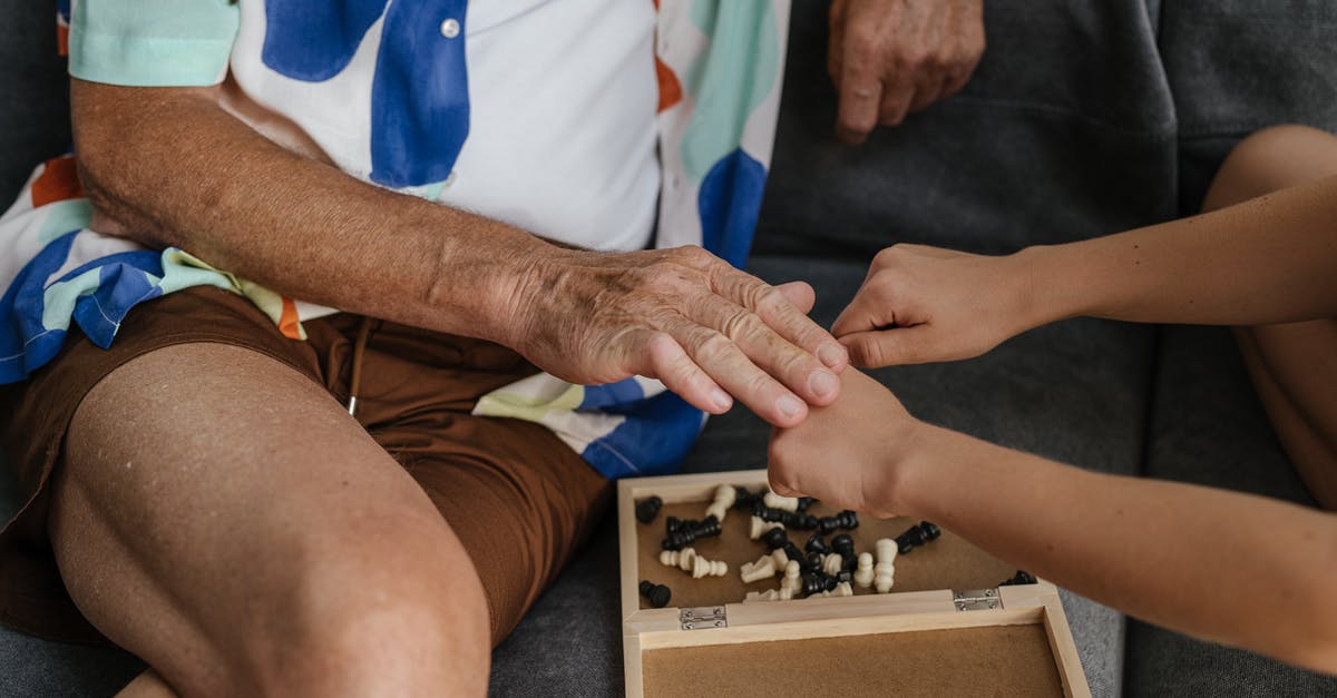 What game did I see in Verona, Italy? - Person in Blue Shirt and White Pants Holding Black and White Chess Piece What game did I see in Verona, Italy? - Person in Blue Shirt and White Pants Holding Black and White Chess Piece