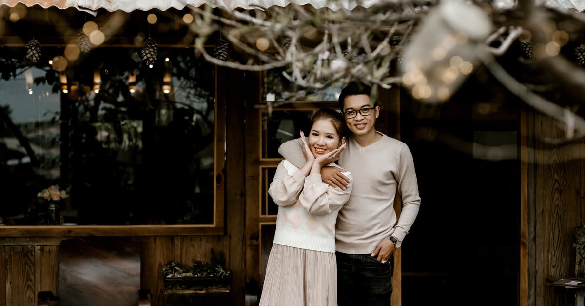 What gifts would be welcome for a Swedish host family? - Smiling young Asian couple on terrace What gifts would be welcome for a Swedish host family? - Smiling young Asian couple on terrace