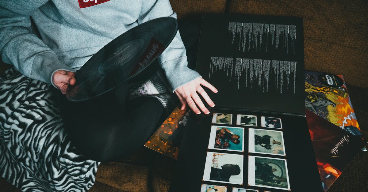 What happens to the immigration record of a person being evacuated/airlifted by their embassy from another country? - From above of crop unrecognizable person in casual clothes sitting on sofa and taking vinyl record at home in daytime