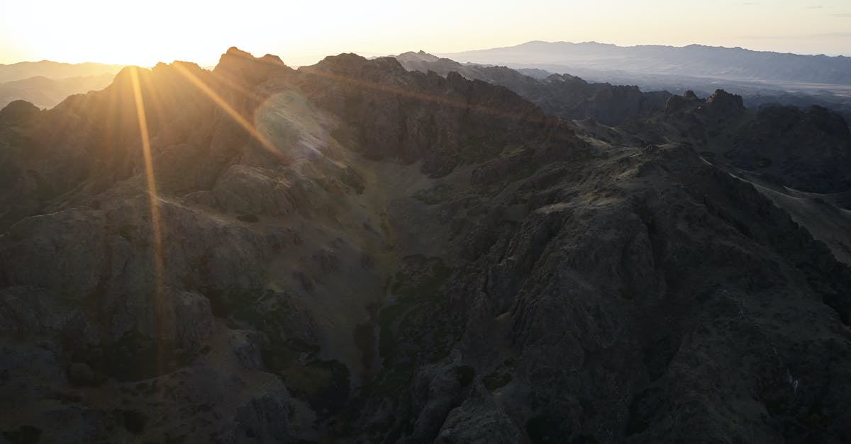 What happens to visas that last longer than a passport? - Majestic drone view of mountain range almost plunged into darkness touched by last sunbeam of setting sun causing lens flare What happens to visas that last longer than a passport? - Majestic drone view of mountain range almost plunged into darkness touched by last sunbeam of setting sun causing lens flare