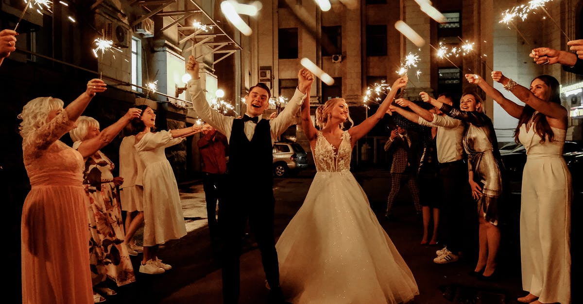 What I need to know when going to typical (traditional) wedding ceremony in Philippines? - Cheerful young bride and groom with guests dancing on street with sparklers in hands during wedding party What I need to know when going to typical (traditional) wedding ceremony in Philippines? - Cheerful young bride and groom with guests dancing on street with sparklers in hands during wedding party
