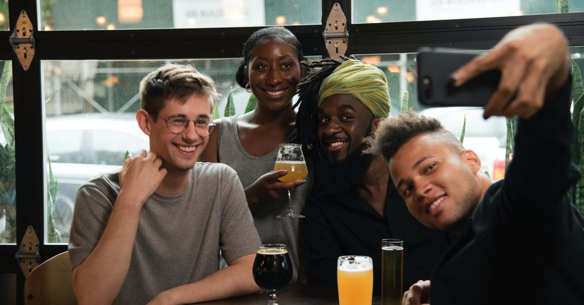 What immigration lane do I use as a group? [closed] - Happy multiethnic friends taking selfie on smartphone in cafe